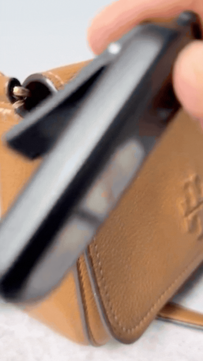 Personal safety alarm being clipped onto  bag
