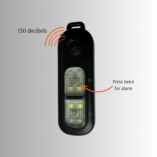 Black personal safety alarm device with LED lights and text indicating decibel level and alarm activation method on a gray background.