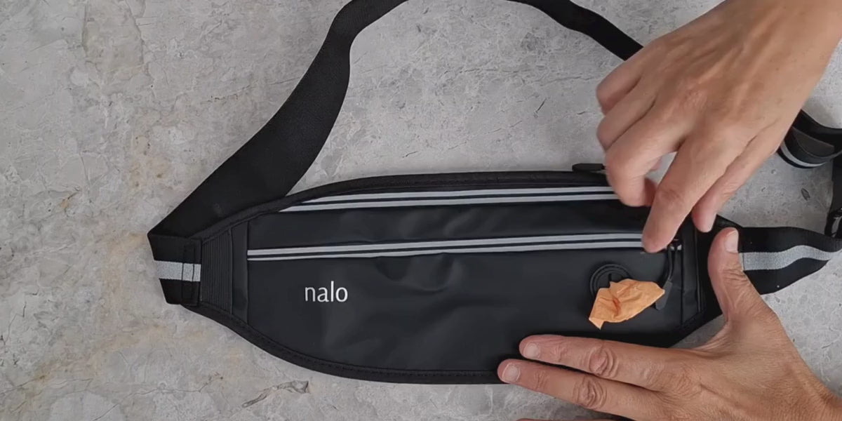Load video: a Video showing a walk through of the Nalo Active bag.  First showing the two compartments, then showing a mobile phone being place inside. Keys fit comfortably in the bag and a seperate compartment for credit cards. Finally a clip on light is attached to loops designed into the bag.